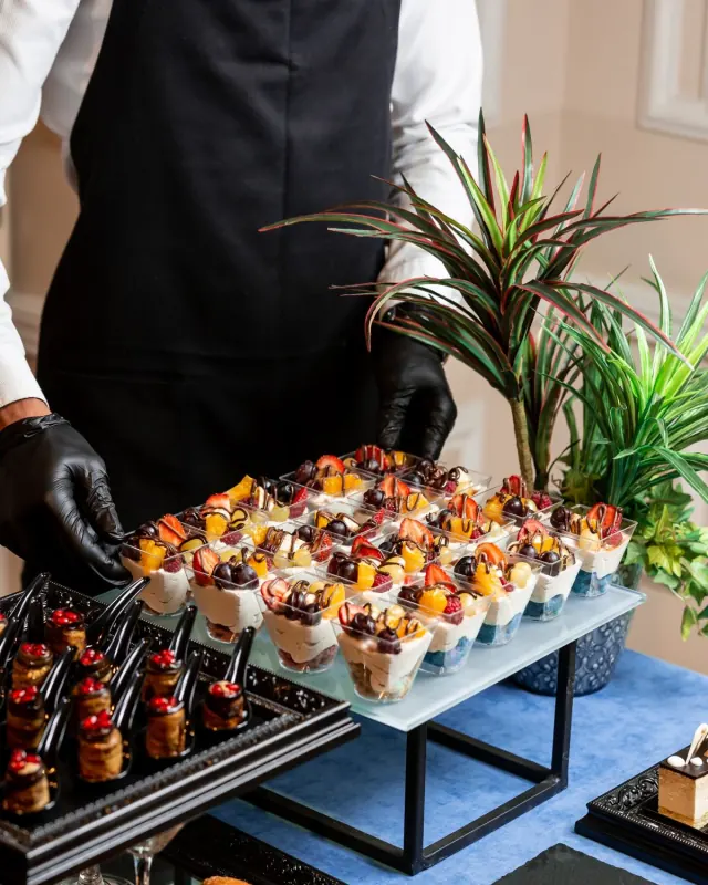 Verrines de fruits frais présentées par un serveur ganté